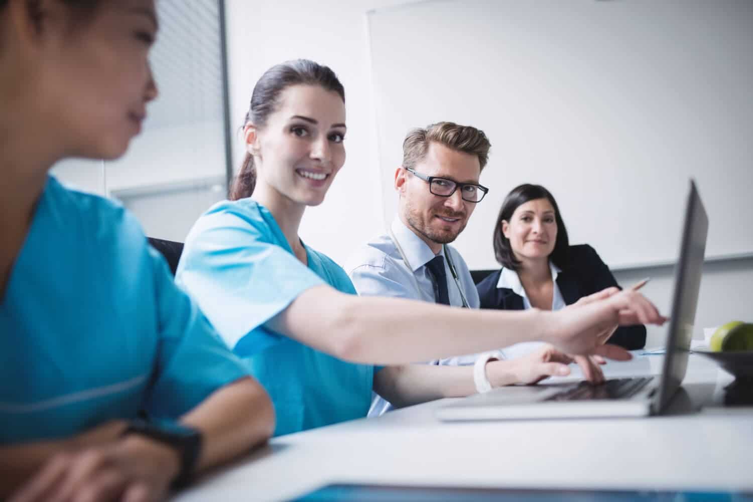 Nursing coursework help - doctors discussing laptop meeting during